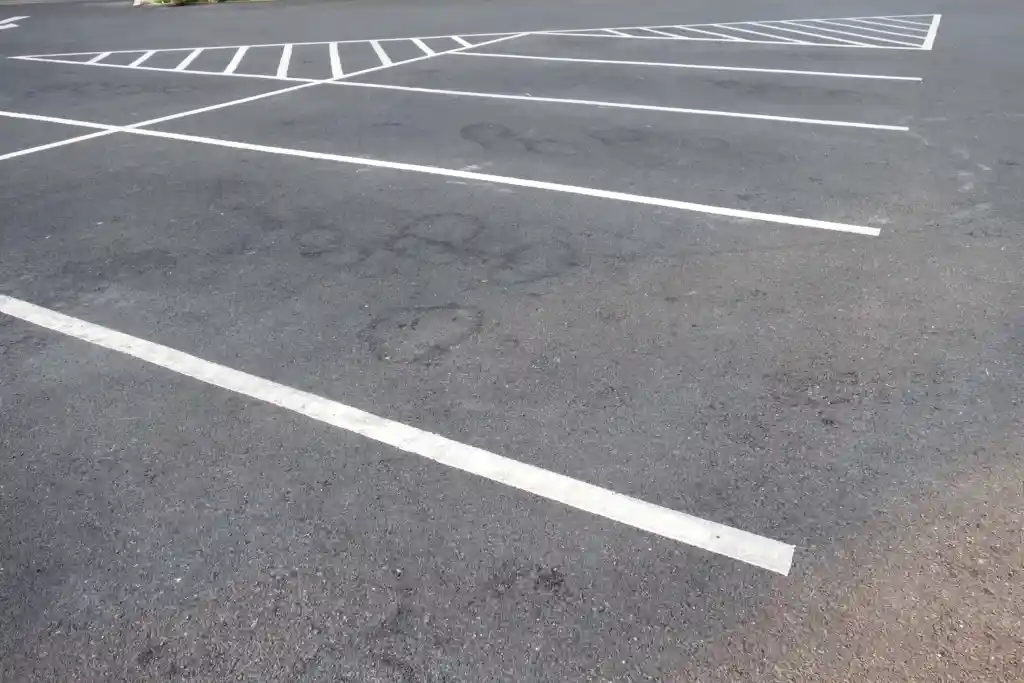 Empty asphalt parking lot with white car park line marking company